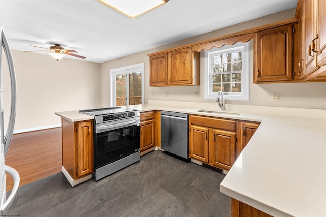 kitchen with appliances with stainless steel finishes, sink, ceiling fan, and kitchen peninsula