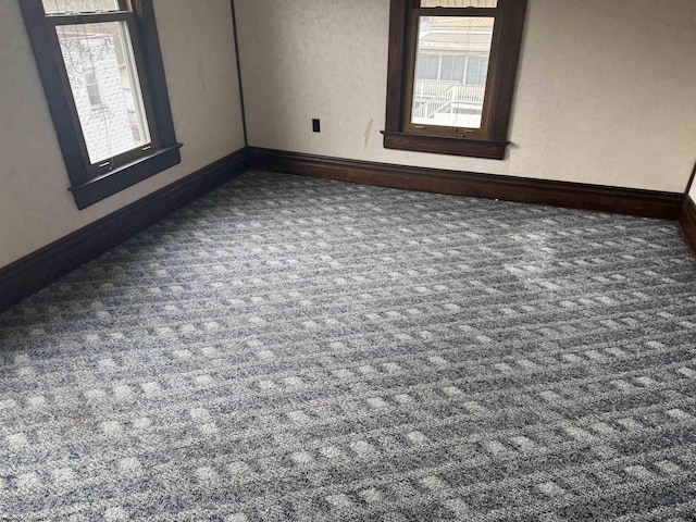 carpeted spare room featuring plenty of natural light