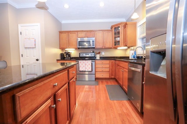 kitchen featuring sink, hanging light fixtures, stainless steel appliances, crown molding, and light wood-type flooring