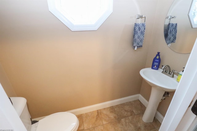 bathroom featuring sink, toilet, a skylight, and tile patterned flooring