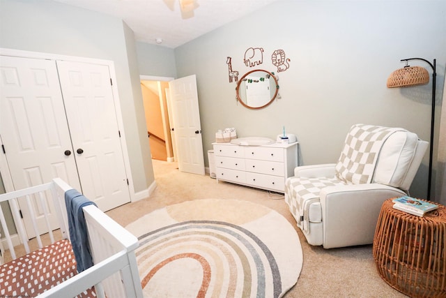 bedroom featuring ceiling fan, light carpet, and a closet