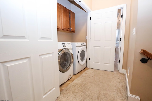 laundry room featuring cabinets, separate washer and dryer, and light colored carpet