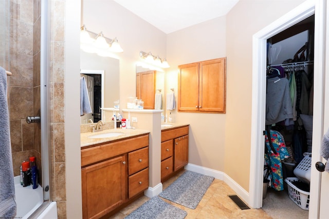 bathroom featuring vanity, tile patterned flooring, and shower / bath combination with glass door