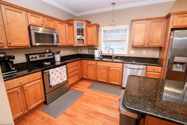 kitchen featuring sink, decorative light fixtures, dark stone countertops, light wood-type flooring, and appliances with stainless steel finishes