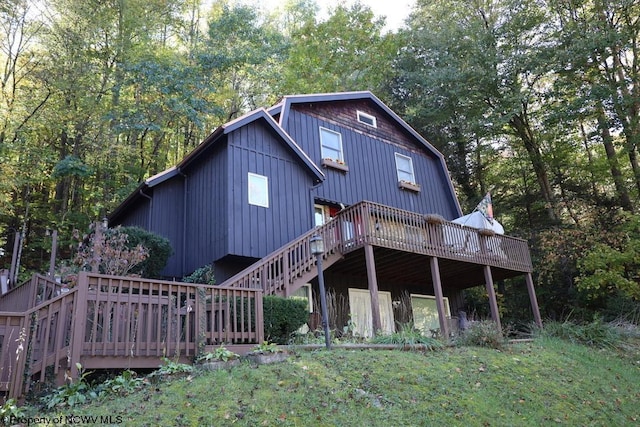 back of property with a wooden deck and a yard