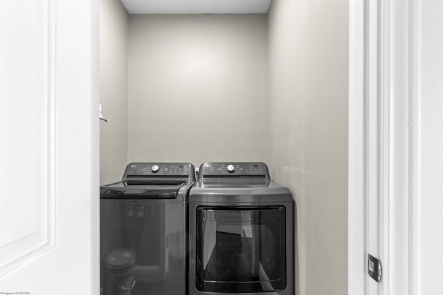 clothes washing area with washing machine and dryer