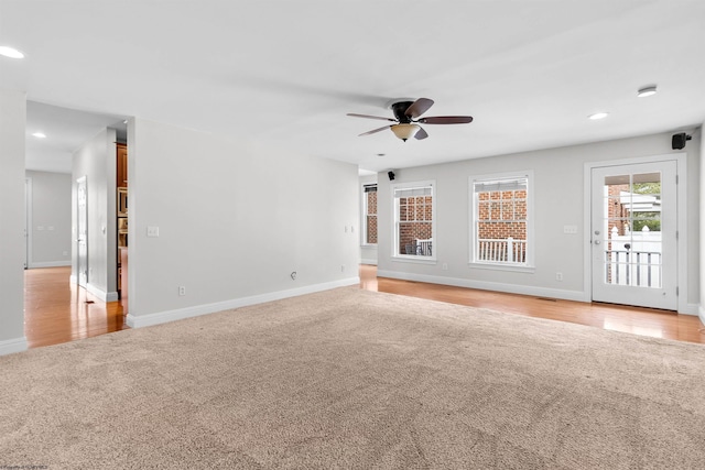 unfurnished living room with light carpet and ceiling fan