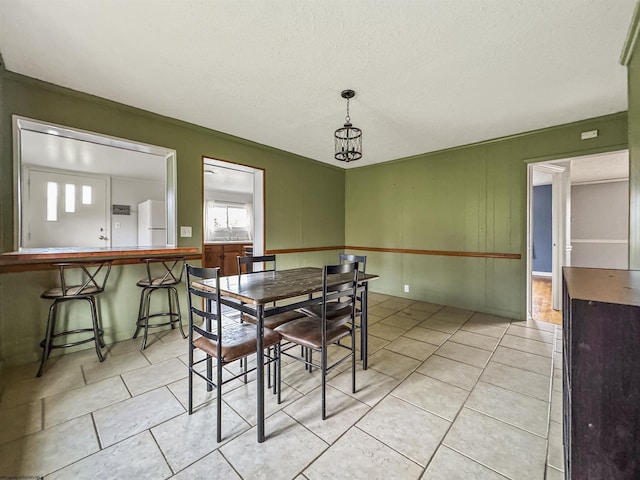 tiled dining area with a textured ceiling