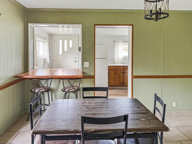 tiled dining room with a textured ceiling