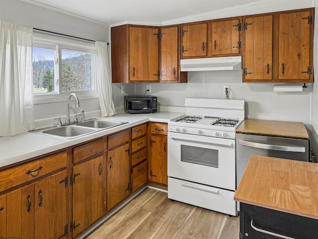 kitchen featuring sink, dishwasher, backsplash, light hardwood / wood-style floors, and white gas stove