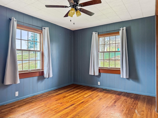 unfurnished room with ceiling fan, plenty of natural light, and light hardwood / wood-style flooring