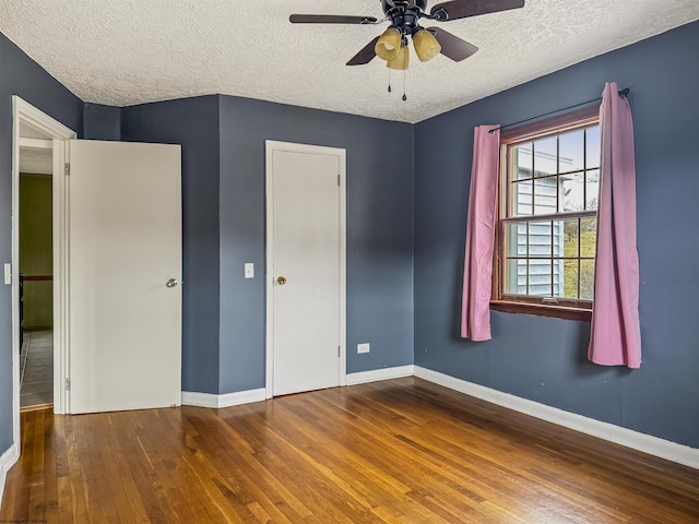 unfurnished bedroom with hardwood / wood-style floors, a textured ceiling, and ceiling fan