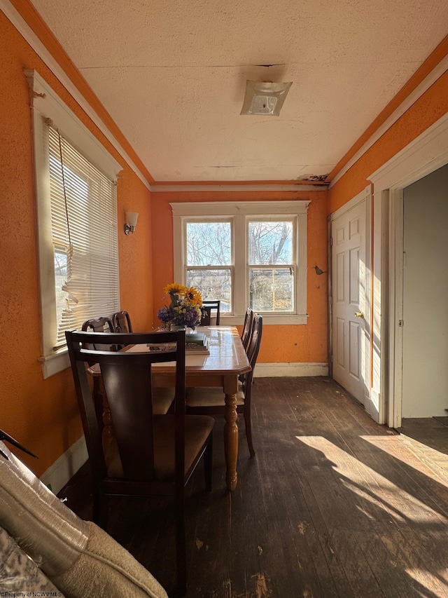 dining area with ornamental molding, dark hardwood / wood-style floors, and a textured ceiling