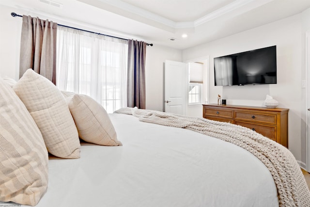 bedroom with crown molding and a tray ceiling