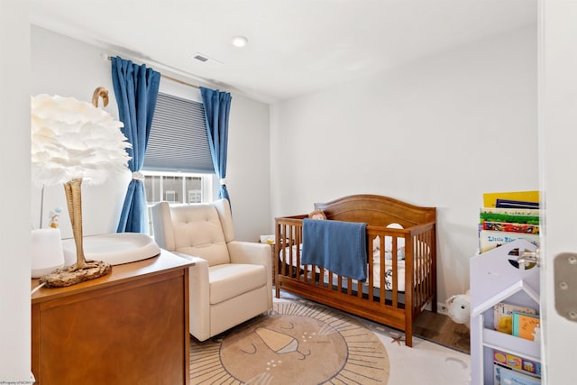 bedroom featuring a crib and light wood-type flooring