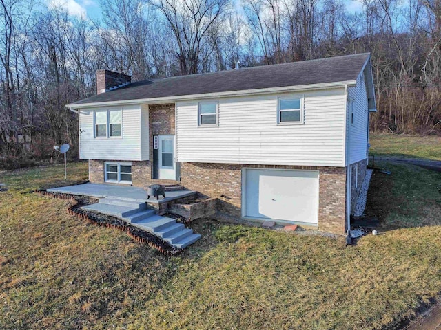 bi-level home featuring a garage and a front lawn