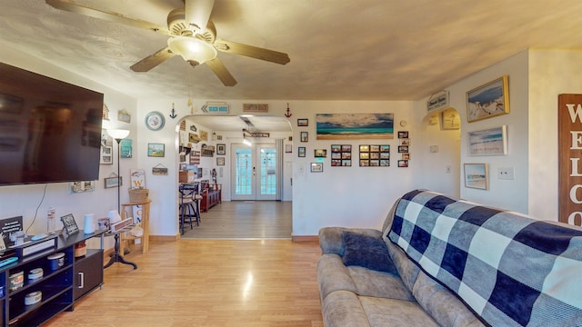 living room featuring french doors, ceiling fan, and light hardwood / wood-style flooring