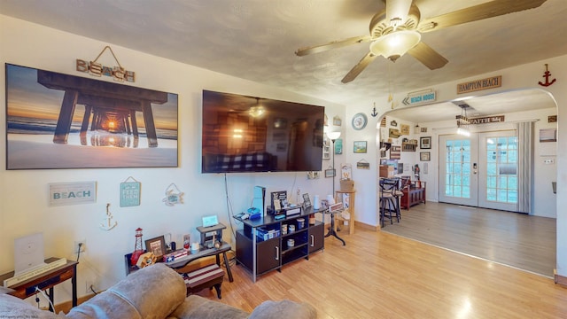 living room featuring ceiling fan, light hardwood / wood-style floors, and french doors