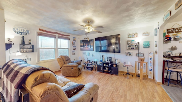 living room featuring ceiling fan, a textured ceiling, and light hardwood / wood-style floors