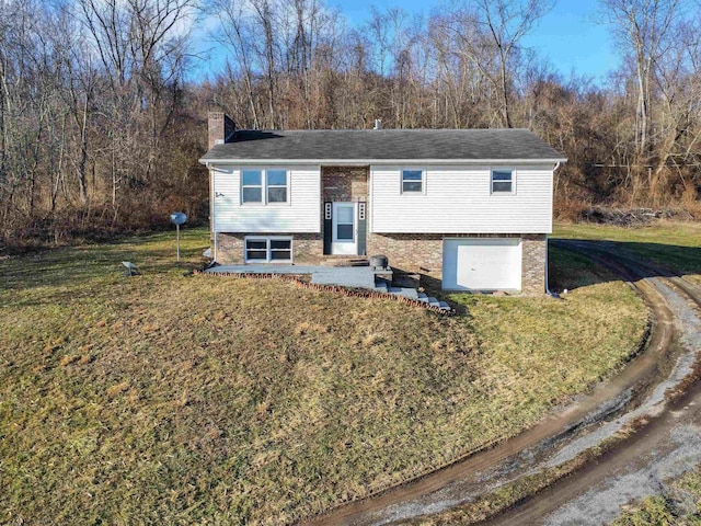 split foyer home with a garage, a patio, and a front lawn