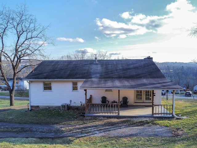 rear view of house featuring central AC unit and a patio area