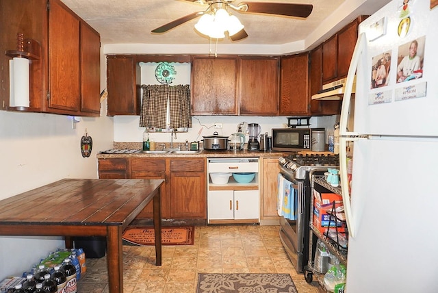 kitchen with sink, gas range, a textured ceiling, white refrigerator, and ceiling fan