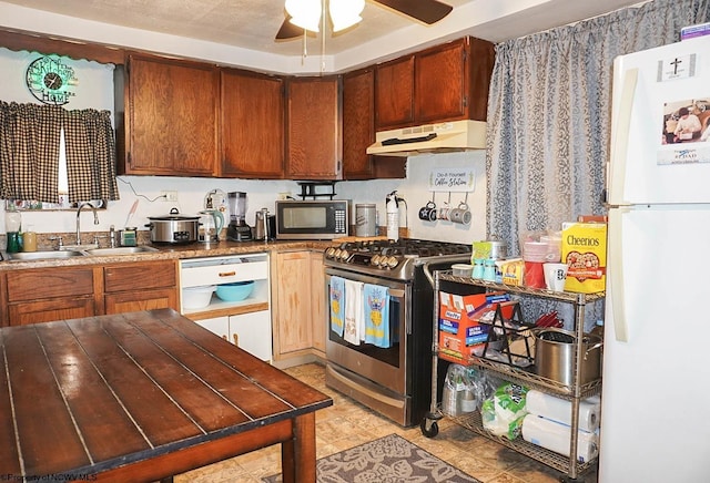 kitchen with white refrigerator, ceiling fan, sink, and stainless steel gas range oven