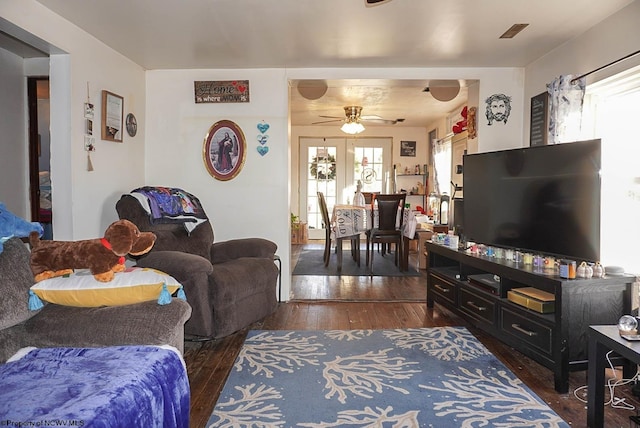 living room with a healthy amount of sunlight, dark wood-type flooring, and ceiling fan