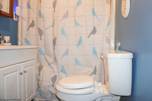 bathroom featuring vanity, tile walls, and toilet