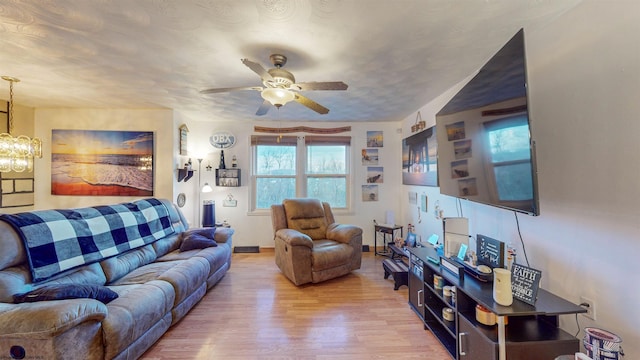 living room featuring hardwood / wood-style floors and ceiling fan with notable chandelier