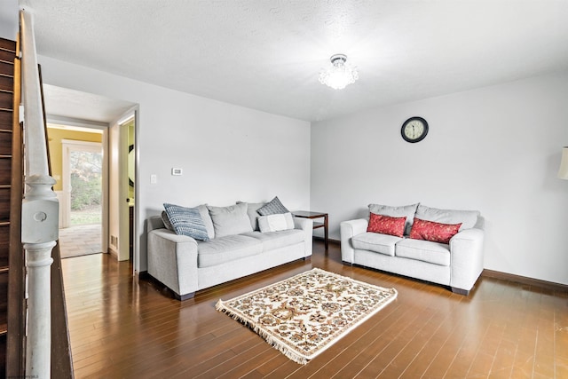 living room featuring dark hardwood / wood-style flooring and a textured ceiling