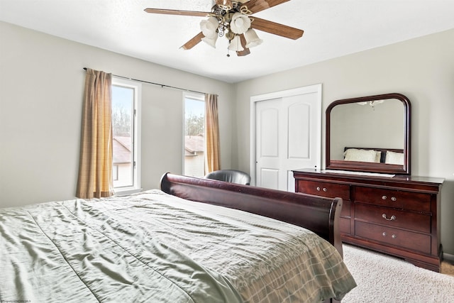 carpeted bedroom with ceiling fan and a closet