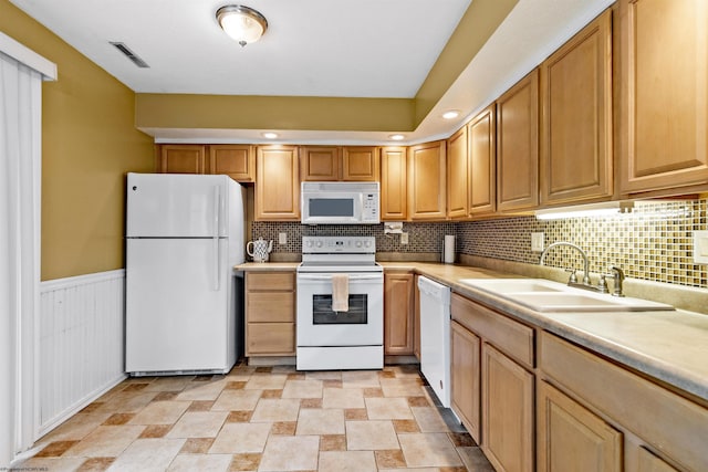 kitchen with tasteful backsplash, white appliances, and sink