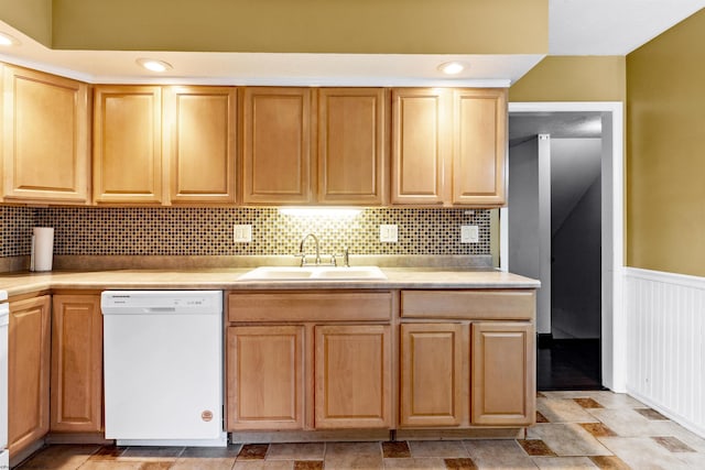 kitchen with sink, white dishwasher, and decorative backsplash