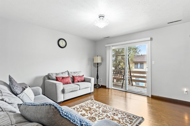 living room featuring hardwood / wood-style flooring and a textured ceiling