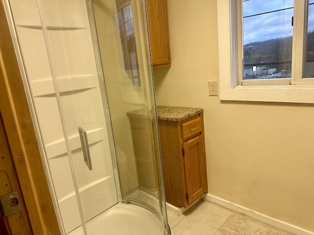 bathroom with tile patterned floors, an enclosed shower, and vanity