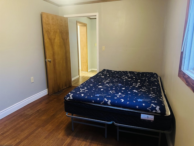 bedroom with dark hardwood / wood-style floors