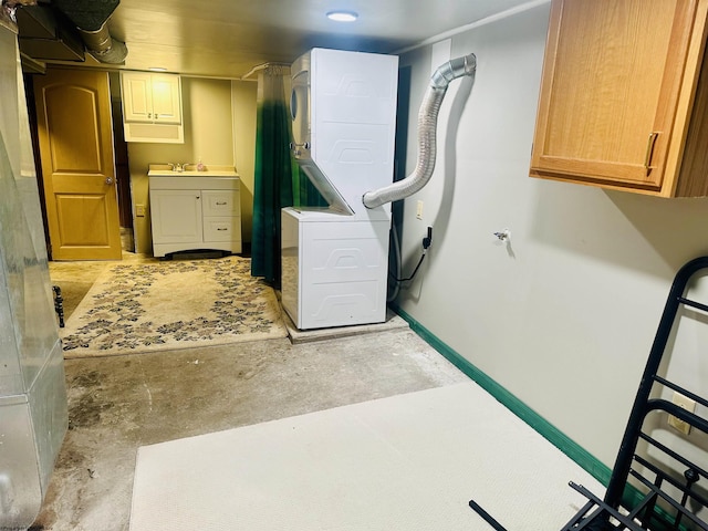 laundry area featuring cabinets and stacked washer and dryer