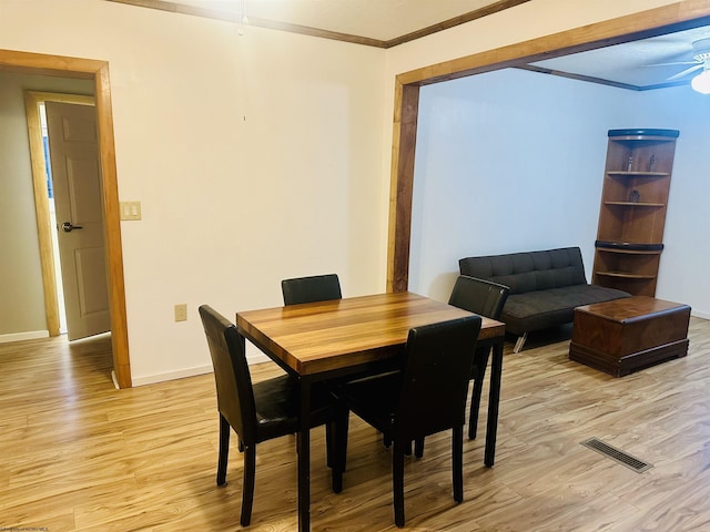 dining area with crown molding, ceiling fan, and light wood-type flooring