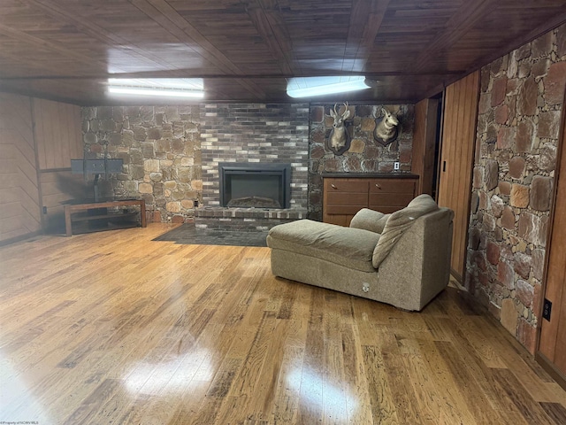 unfurnished living room featuring a glass covered fireplace, wood ceiling, and hardwood / wood-style flooring