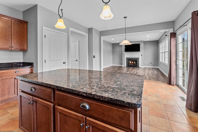 kitchen featuring hanging light fixtures, a kitchen island, and light tile patterned floors