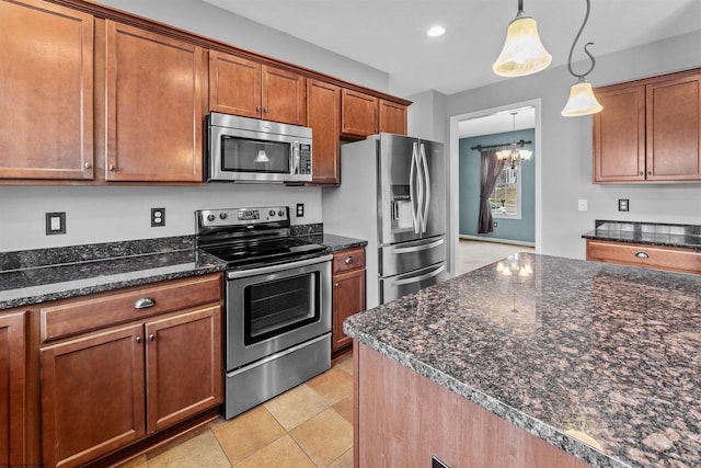 kitchen with an inviting chandelier, appliances with stainless steel finishes, decorative light fixtures, and dark stone counters