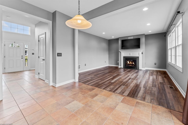 unfurnished living room featuring light hardwood / wood-style flooring and a wealth of natural light