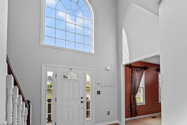 foyer with a towering ceiling and plenty of natural light