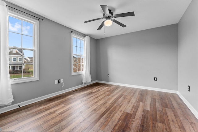 empty room with hardwood / wood-style floors and ceiling fan