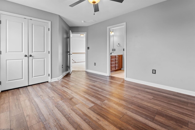 unfurnished bedroom with ceiling fan, ensuite bath, light hardwood / wood-style floors, and a closet