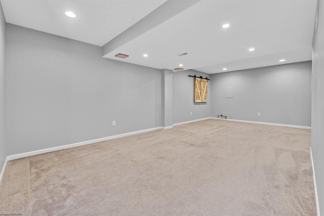 basement with carpet floors and a barn door