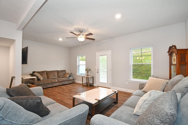 living room with dark wood-type flooring and ceiling fan