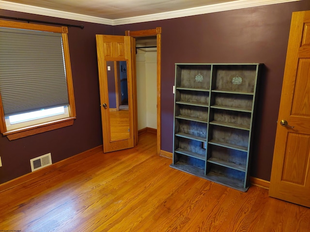 unfurnished bedroom with ornamental molding and light hardwood / wood-style floors