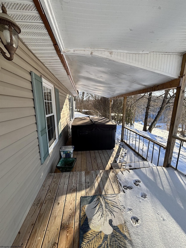 snow covered deck with a covered hot tub